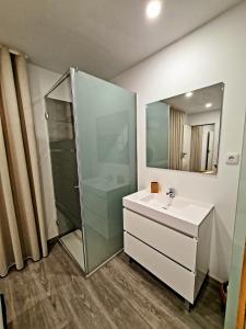 加亚新城VILLAS com piscina的带淋浴、盥洗盆和镜子的浴室