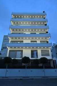 雅典The Lop Athens Holidays Luxury Suites的一座高大的白色建筑,灯火通明
