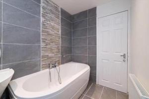 格拉斯哥Light-luxury Flat的一间带白色浴缸和白色门的浴室