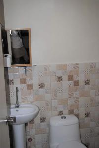 麦克坦Cozy Inn Mactan的浴室配有白色卫生间和盥洗盆。