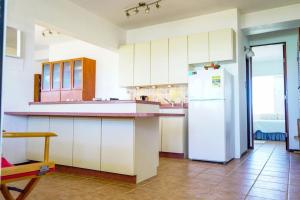 卡沃罗霍Ocean View, Playas del Caribe的厨房配有白色橱柜和白色冰箱。