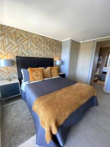 康康Departamento Dunas de Concón的一间卧室配有带橙色枕头的大型蓝色床
