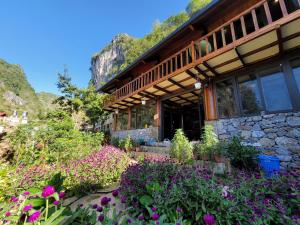 同文DONG VAN CLIFFSIDE HOUSE的前面有鲜花的建筑