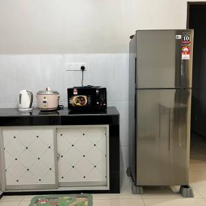 艾尔克如Homestay Ayer Keroh Tasik Utama的厨房配有微波炉和冰箱。