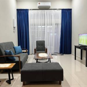 艾尔克如Homestay Ayer Keroh Tasik Utama的带沙发、电视和蓝色窗帘的客厅