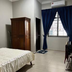 艾尔克如Homestay Ayer Keroh Tasik Utama的一间卧室配有一张床、一个梳妆台和一扇窗户。