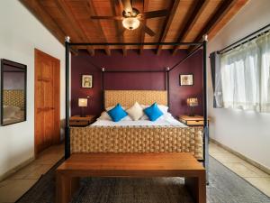马利纳尔科Hotel Amate del Rio的一间卧室配有一张带蓝色枕头的天蓬床