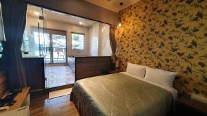 乌来乌来水岸温泉馆的一间卧室配有一张带华丽墙壁的床