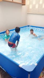 洛斯拉甘斯Casa Entre Rocas y Veleros的3名儿童在游泳池玩耍