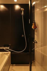 东京NPlus Hotel 东神田-秋叶原的带淋浴的浴室(带黑色墙壁)