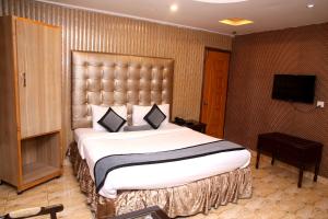 拉合尔Premier inn Mall Lahore的酒店客房设有一张大床和一台电视。