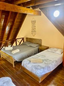 圣安德烈斯Cabaña Diana的阁楼间设有两张床铺和木制天花板