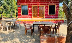 Revadandapratik Mango farm house的一组桌子和椅子在房子前面