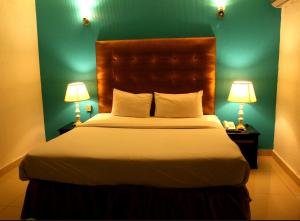 拉合尔Premier inn Mall Lahore的一间卧室配有一张大床和两盏灯