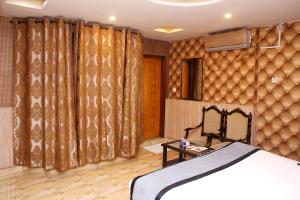拉合尔Premier inn Mall Lahore的一间卧室配有床和窗帘的墙