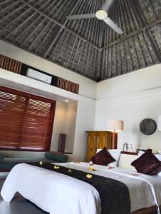 艾湄湾武吉瑟加拉别墅酒店的一间卧室设有两张床和天花板