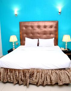 拉合尔Premier inn Mall Lahore的一间卧室设有一张蓝色墙壁的大床