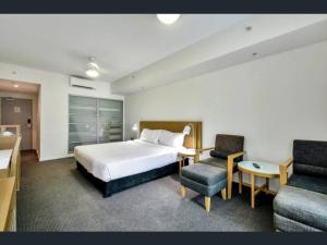 达尔文Executive Studio Darwin CBD (Water Views)的酒店客房配有床、沙发和椅子