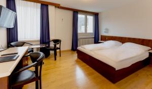 巴登Hotel Linde - 24h Self Check-in的酒店客房,配有一张床、一张桌子和椅子