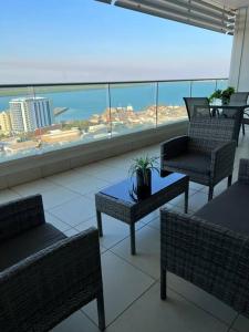达尔文Above & Beyond (21st floor two bedrooms apartment)的客房设有桌椅和大窗户。