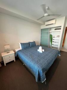达尔文Above & Beyond (21st floor two bedrooms apartment)的一间卧室配有一张带蓝色棉被的大床