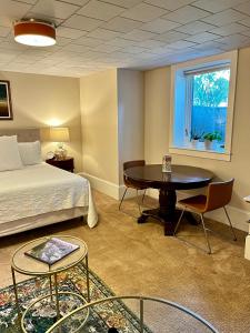 波特兰Dougan Suites的一间卧室配有一张床、一张桌子和一个窗户。