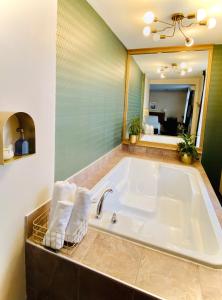 蒙特利尔Maison Cartier Montreal的一间带毛巾和镜子的浴缸的浴室
