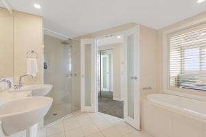 金斯克里福2BR Oceanview Penthouse @ Mantra Salt Resort by uHoliday的浴室配有2个盥洗盆、浴缸和淋浴。