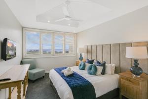 金斯克里福2BR Oceanview Penthouse @ Mantra Salt Resort by uHoliday的一间卧室配有一张带蓝色枕头的大床