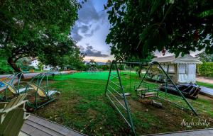 舍亚尔雅舒弗努瑞尔水果及宾馆的公园,公园内有游乐场和绿色庭院