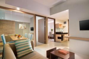 茂物Swiss-Belcourt Bogor的客厅和带沙发及桌子的用餐室