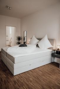 维尔茨堡JAMA - Modern&Bright, Terrasse, Freies Parken, WLAN, Große Gruppen #1的白色卧室铺有木地板,配有一张大白色床。