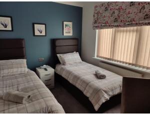 埃奇韦尔Room in Guest room - Apple House Wembley Twin Room的一间卧室设有两张床和窗户。
