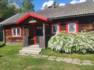 莫拉Mora Life, Åmåsängsgården的草上红色门的小木屋