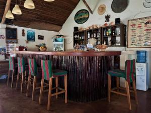 MohéliMoheli Laka Lodge的一间酒吧,配有绿色椅子和木台