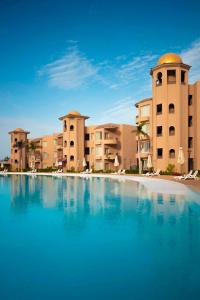 塞得港Marom Port Said Resort的一座大型游泳池,位于部分建筑前