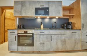 迈斯霍芬Appartement Atzingerberg的厨房配有不锈钢用具和微波炉