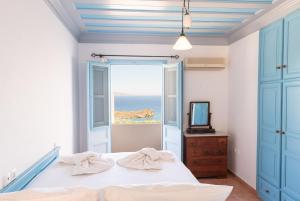 斯科拉Patmos Exclusive Villas的一间卧室配有一张床,享有海景