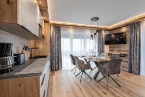 巴特霍夫加施泰因Apartment NH96 inklusive kostenfreiem Eintritt in die Alpentherme的厨房以及带桌椅的用餐室。