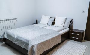 阿尔巴尤利亚Vila Carolina Apulum的一张带白色床单和枕头的床