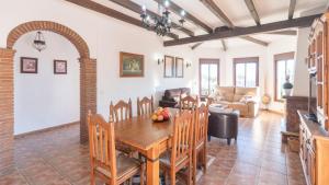 IznateMirador Las Claras Iznate by Ruralidays的厨房以及带木桌和椅子的客厅。