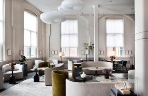 阿姆斯特丹Pillows Grand Boutique Hotel Maurits at the Park - Small Luxury Hotels的大堂设有桌椅和窗户。