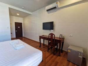 那空拍侬府โรงแรมรชาโขง Racha Khong Hotel的一间卧室配有一张床和一张书桌及电视