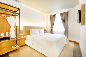 普卡佩索纳阿拉姆度假酒店的卧室设有一张白色大床和一扇窗户。