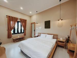 Bien HoXOM House Biển Hồ的卧室配有白色的床和窗户。