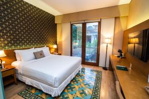 日惹Abhayagiri - Sumberwatu Heritage Resort的酒店客房设有一张床和一个大窗户