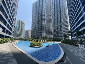 马尼拉Homey 1 Bedroom Unit at Air Residences的一座位于城市的游泳池,有高大的建筑