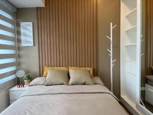 马尼拉Homey 1 Bedroom Unit at Air Residences的一间卧室配有一张大床和木制床头板