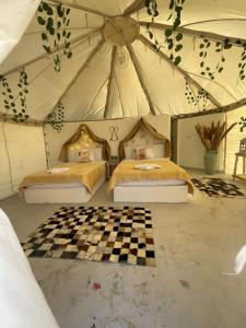 Qasr Al FarafirahShahrazad Camp in white desert, Egypt的一间帐篷内带两张床的卧室