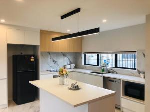 奥克兰Modern & Luxurious Home 2的厨房配有黑色冰箱和台面